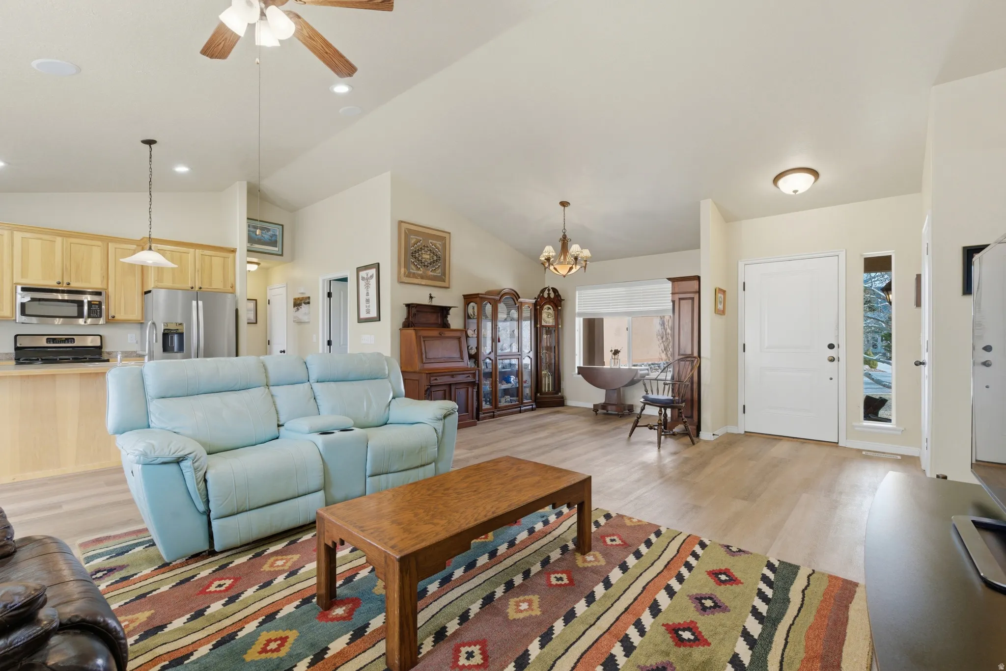Vaulted ceiling living area featuring LVP flooring, a ceiling fan, and recessed lighting