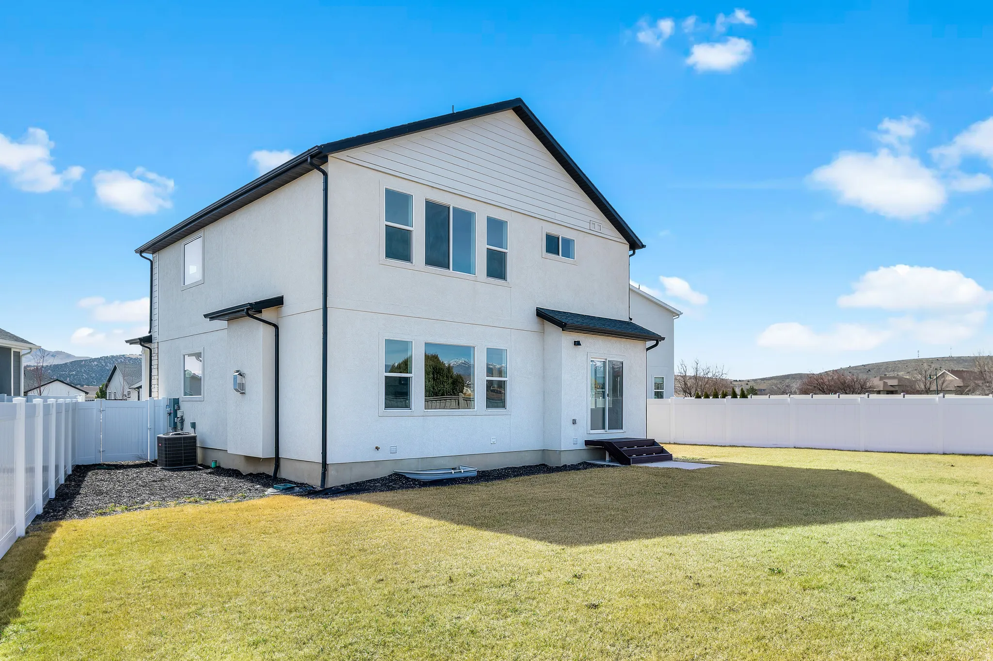 Back of house featuring a fenced backyard and stucco siding