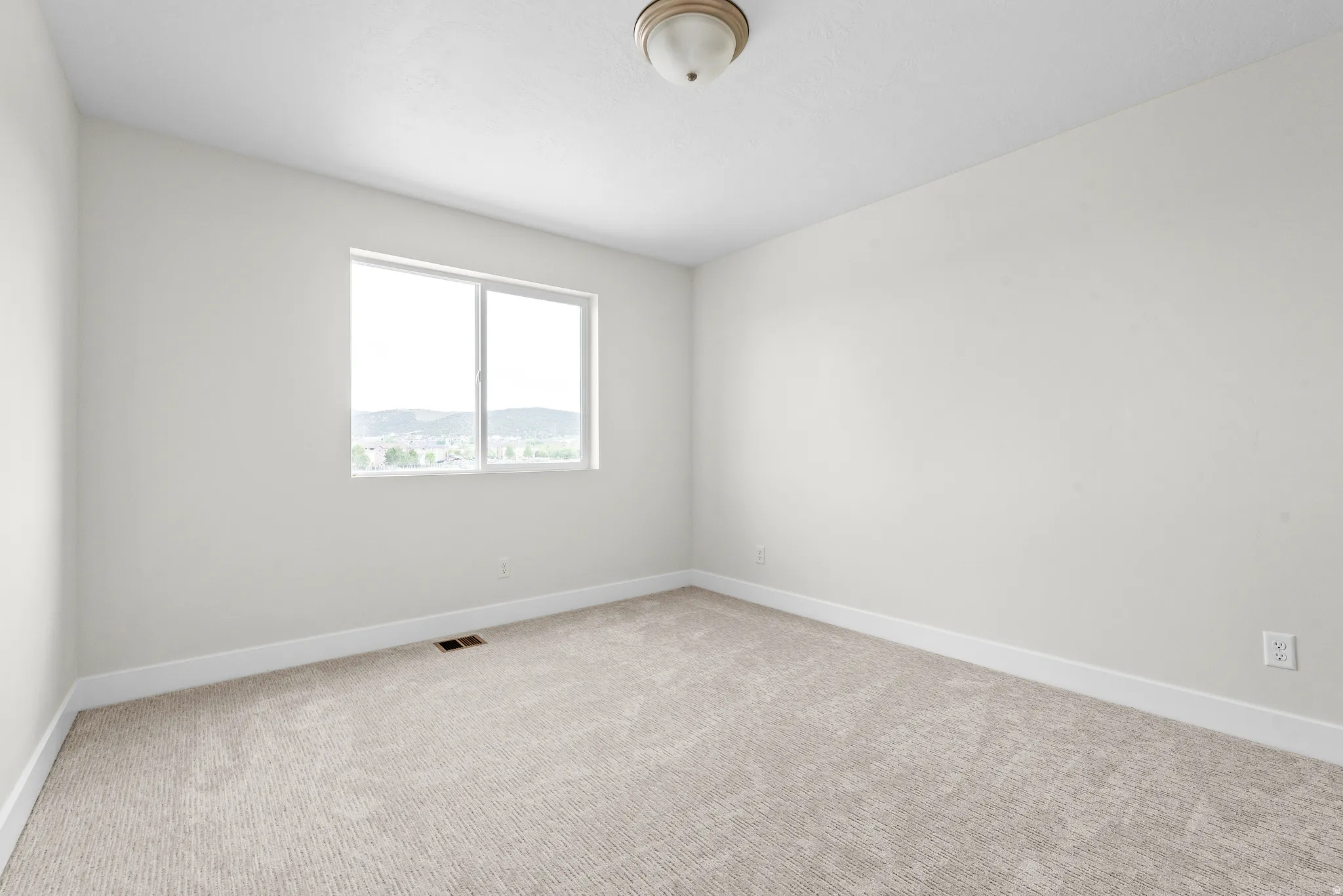 Unfurnished room featuring baseboards and light colored carpet