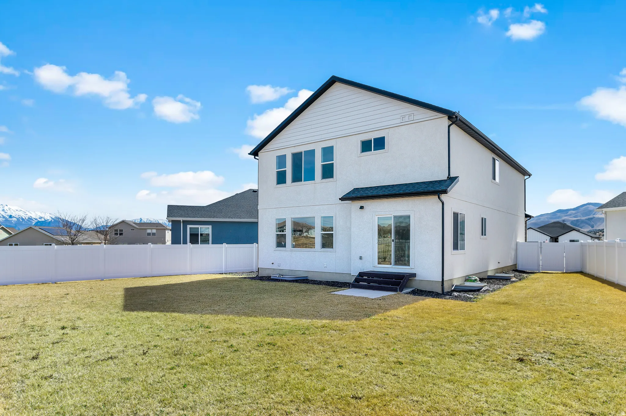 Back of house featuring a fenced backyard, a gate, stucco siding, a patio area, and entry steps