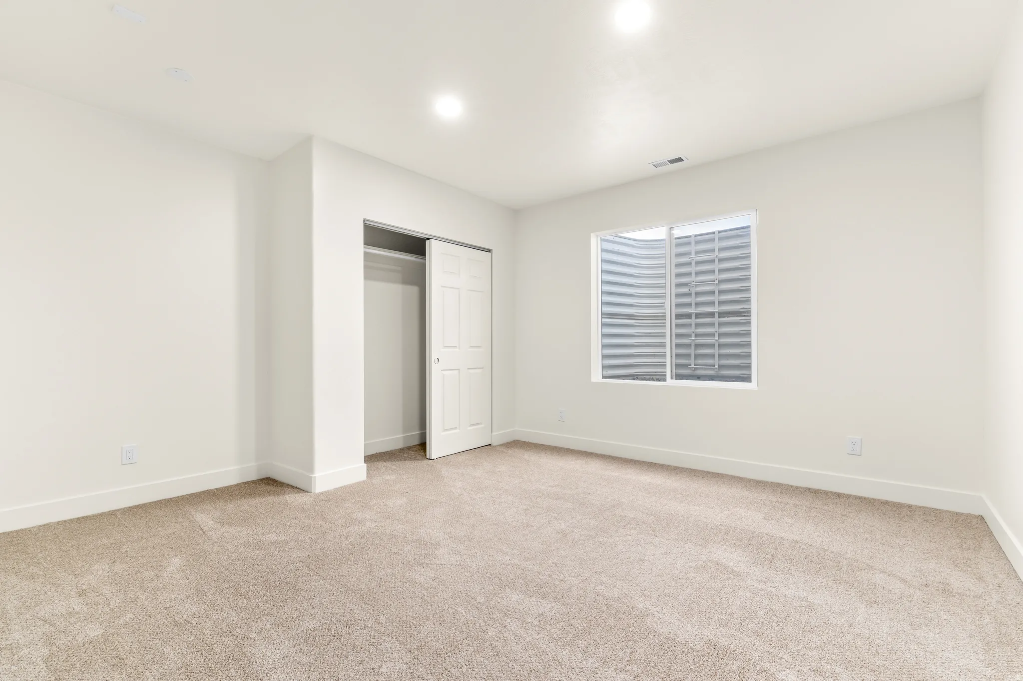 Unfurnished bedroom with light carpet and a closet