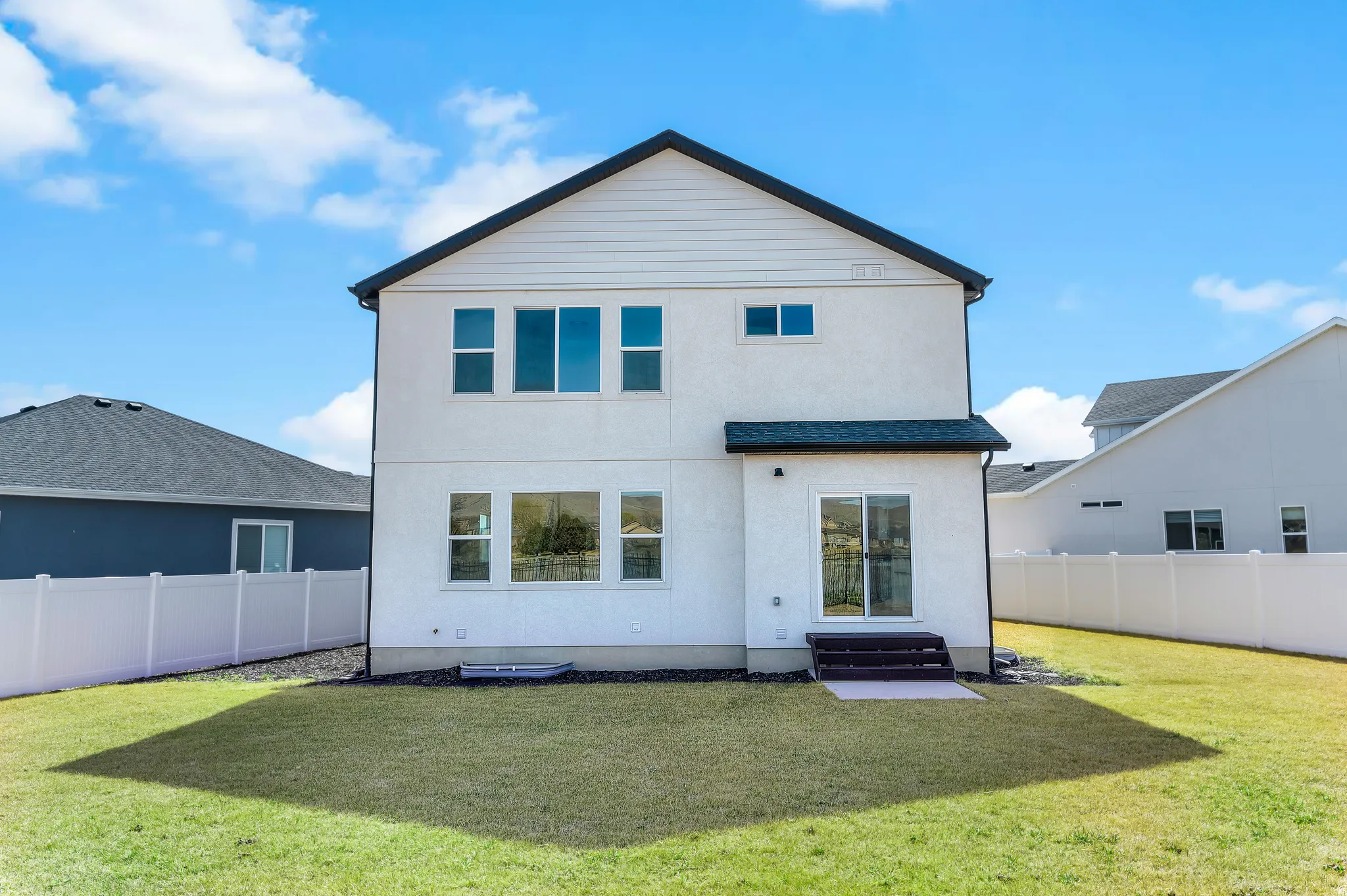 Rear view of property featuring a fenced backyard, stucco siding, and a patio