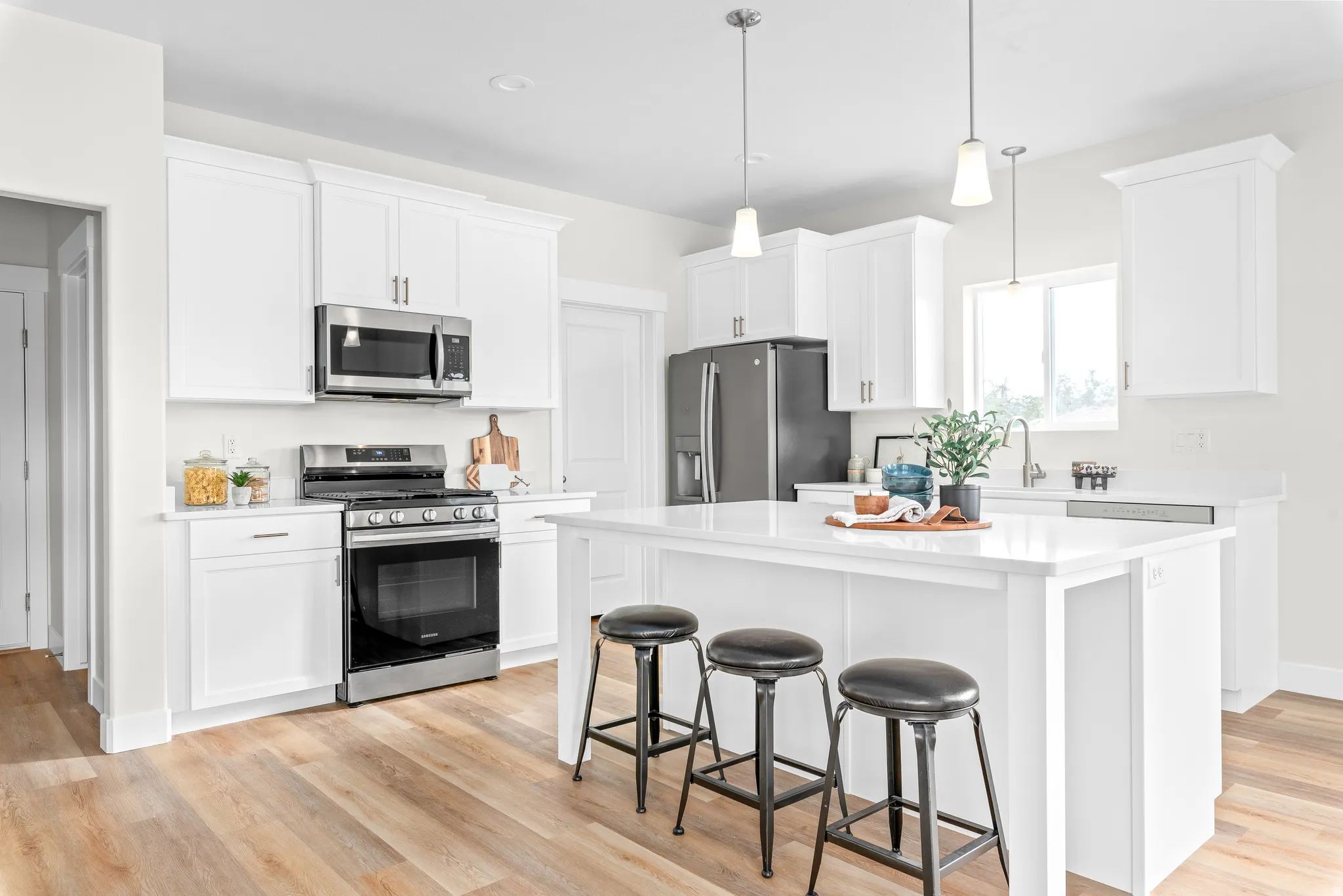 Kitchen featuring stainless steel appliances, a breakfast bar area, white cabinets, and a kitchen island