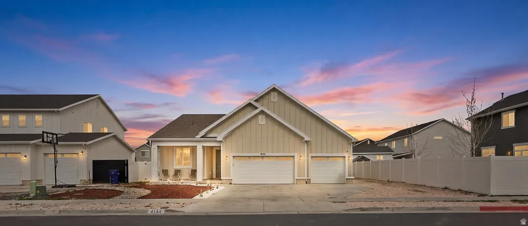 View of front of house with concrete driveway, board and batten siding, and a garage