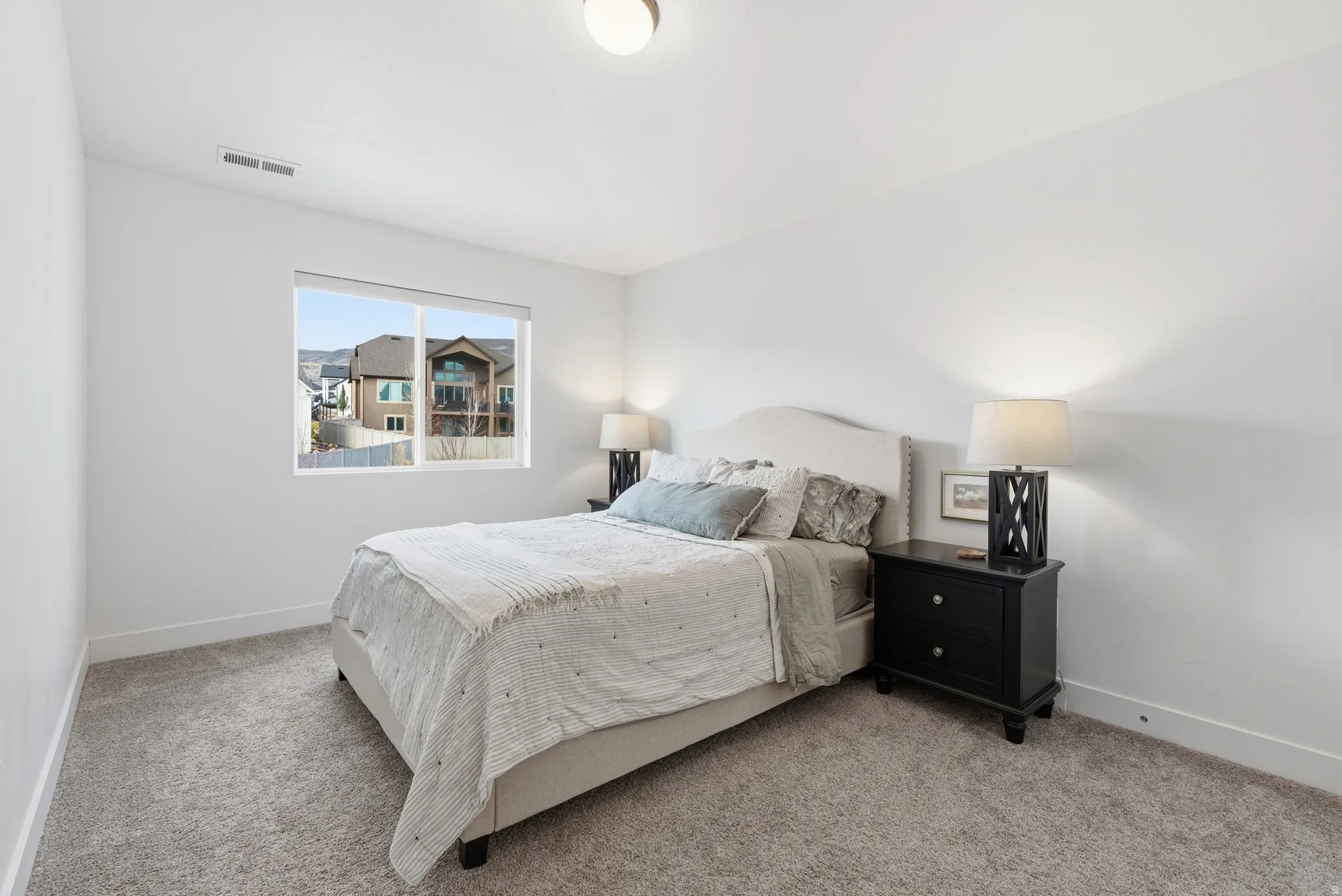 Bedroom with baseboards and light carpet