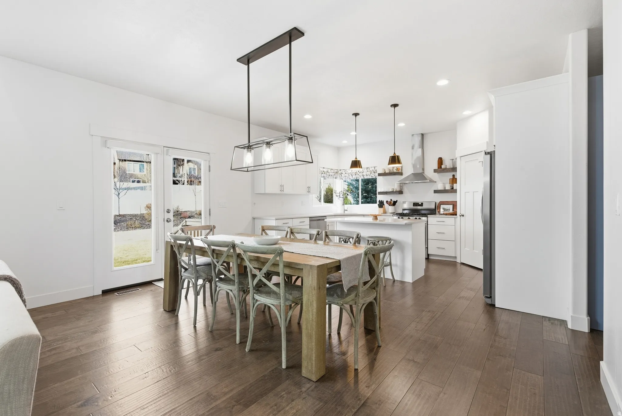 Dining room with dark wood-type flooring and recessed lighting