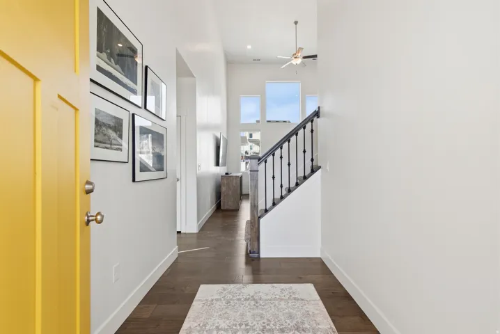 Foyer featuring dark wood-style flooring, ceiling fan, and a high ceiling