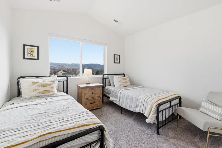 Bedroom with lofted ceiling, dark colored carpet, and a mountain view