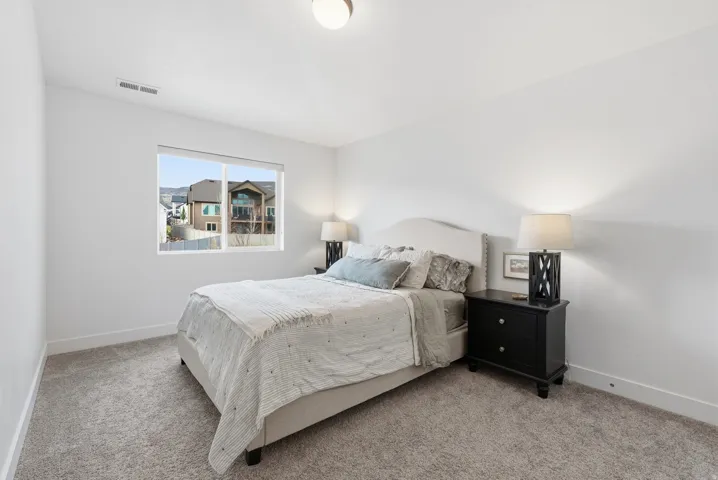 Bedroom with baseboards and light carpet