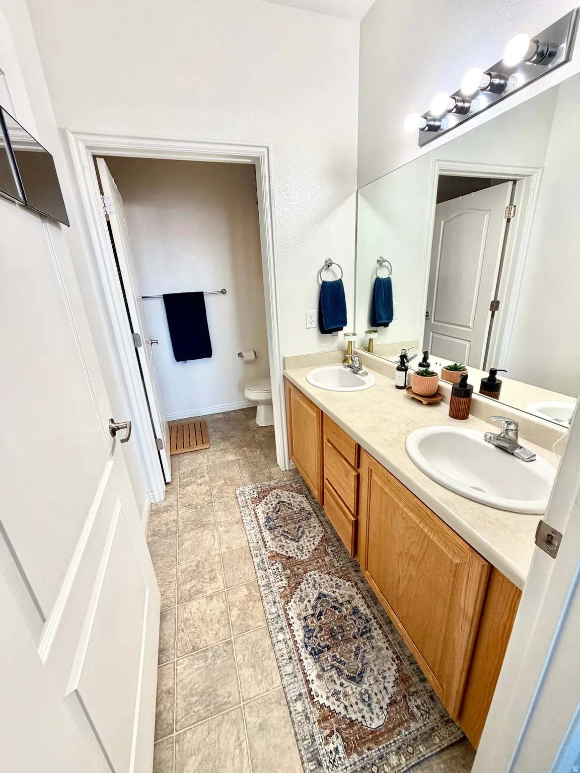 Bathroom featuring toilet and double vanity