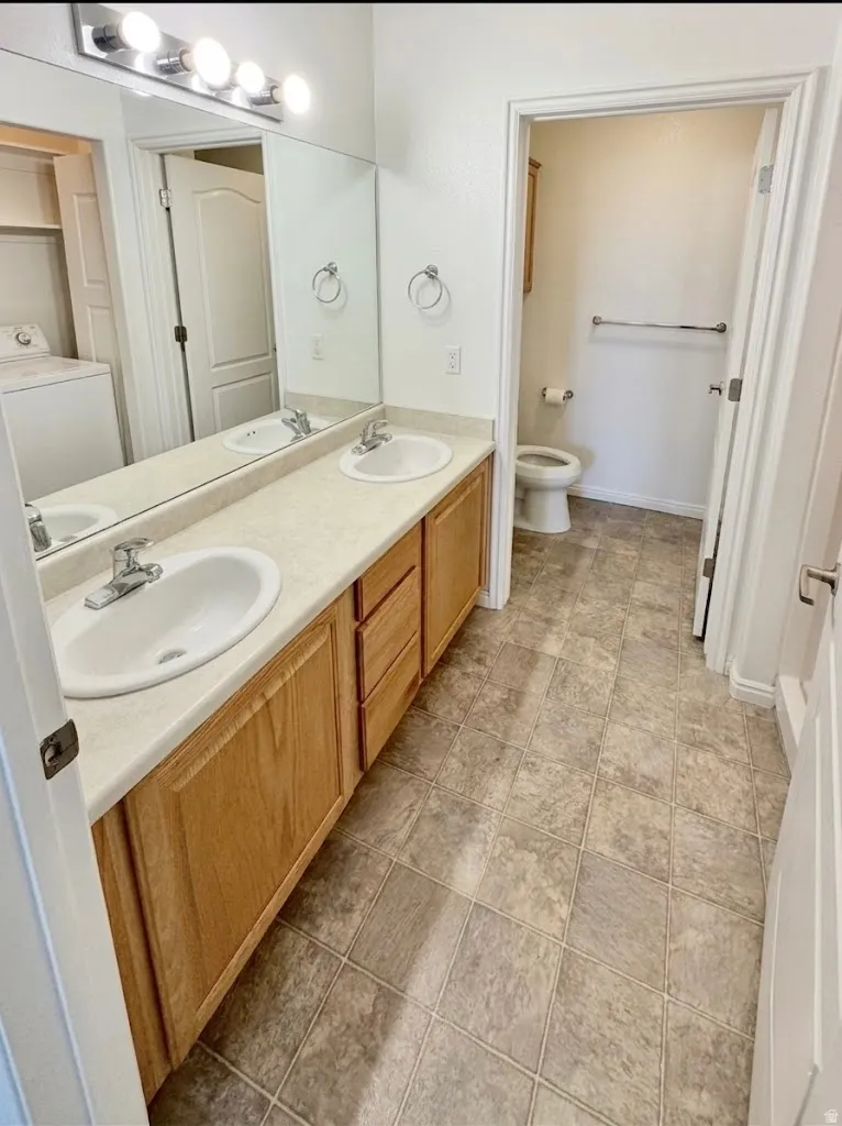 Bathroom featuring washer / dryer and double vanity
