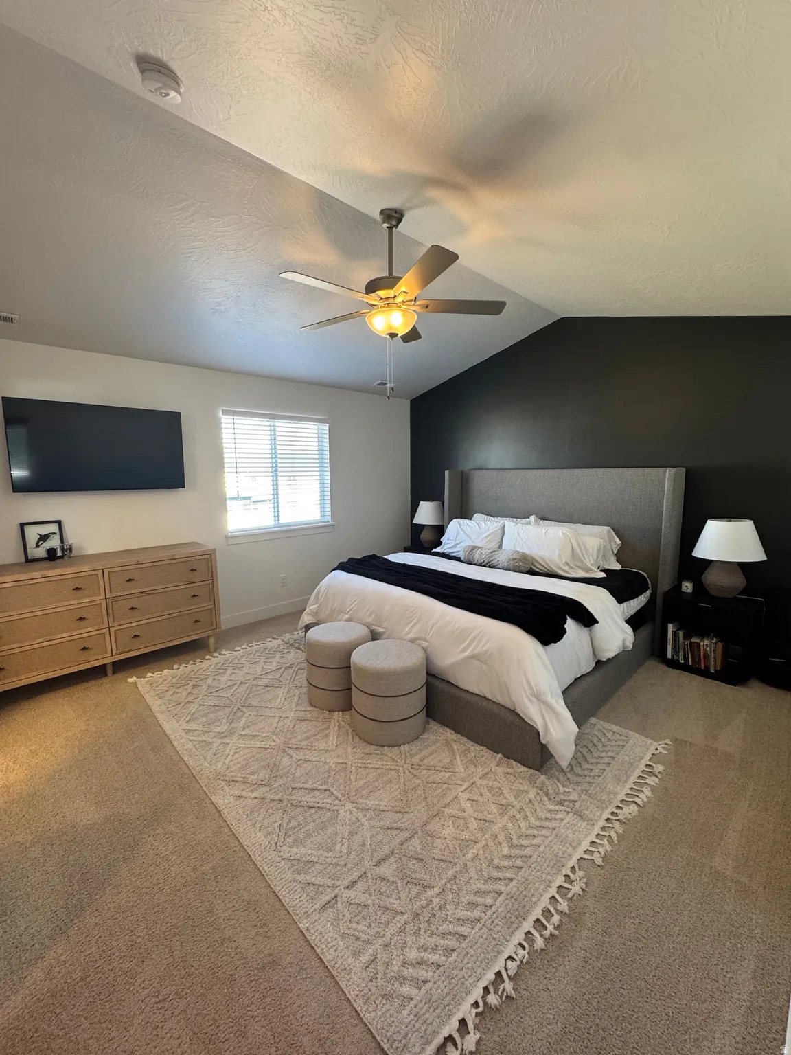 Bedroom with light colored carpet and a ceiling fan