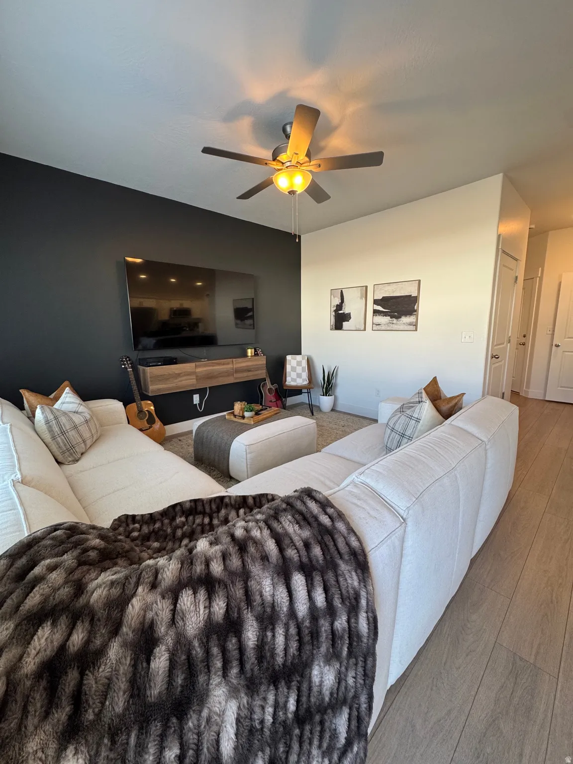 Living area featuring wood finished floors and a ceiling fan