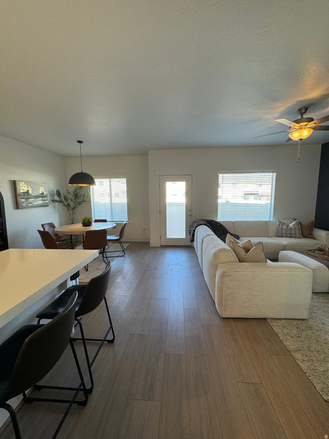 Living area featuring dark wood-style floors and ceiling fan