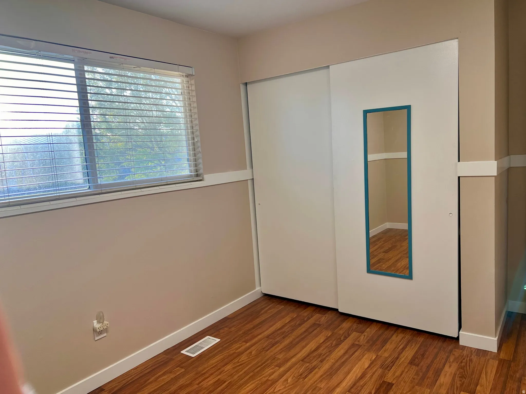 Unfurnished bedroom with dark wood-type flooring and a closet