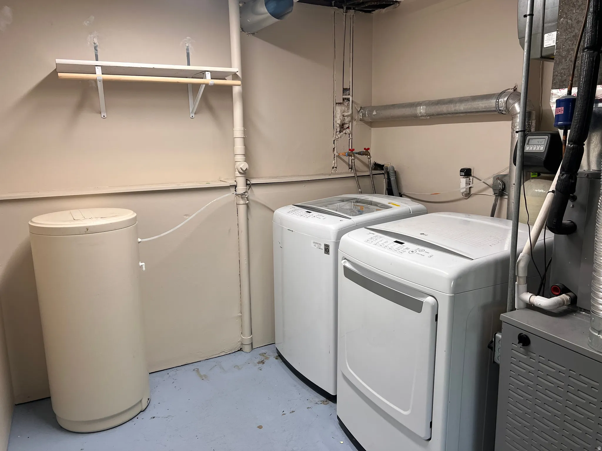 Laundry area with concrete floors, heating unit, and separate washer and dryer