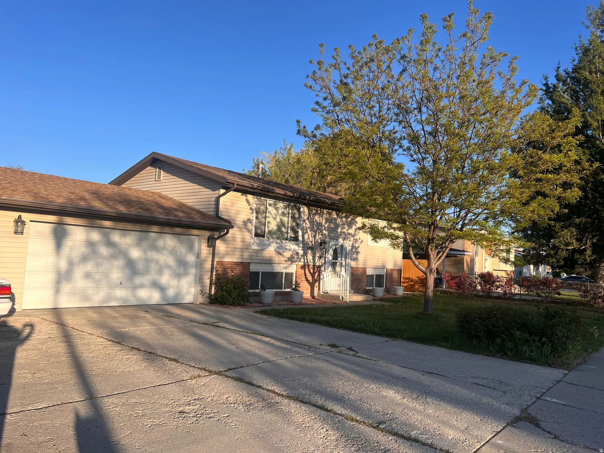 View of front of house with driveway, brick siding, a garage, and a front lawn
