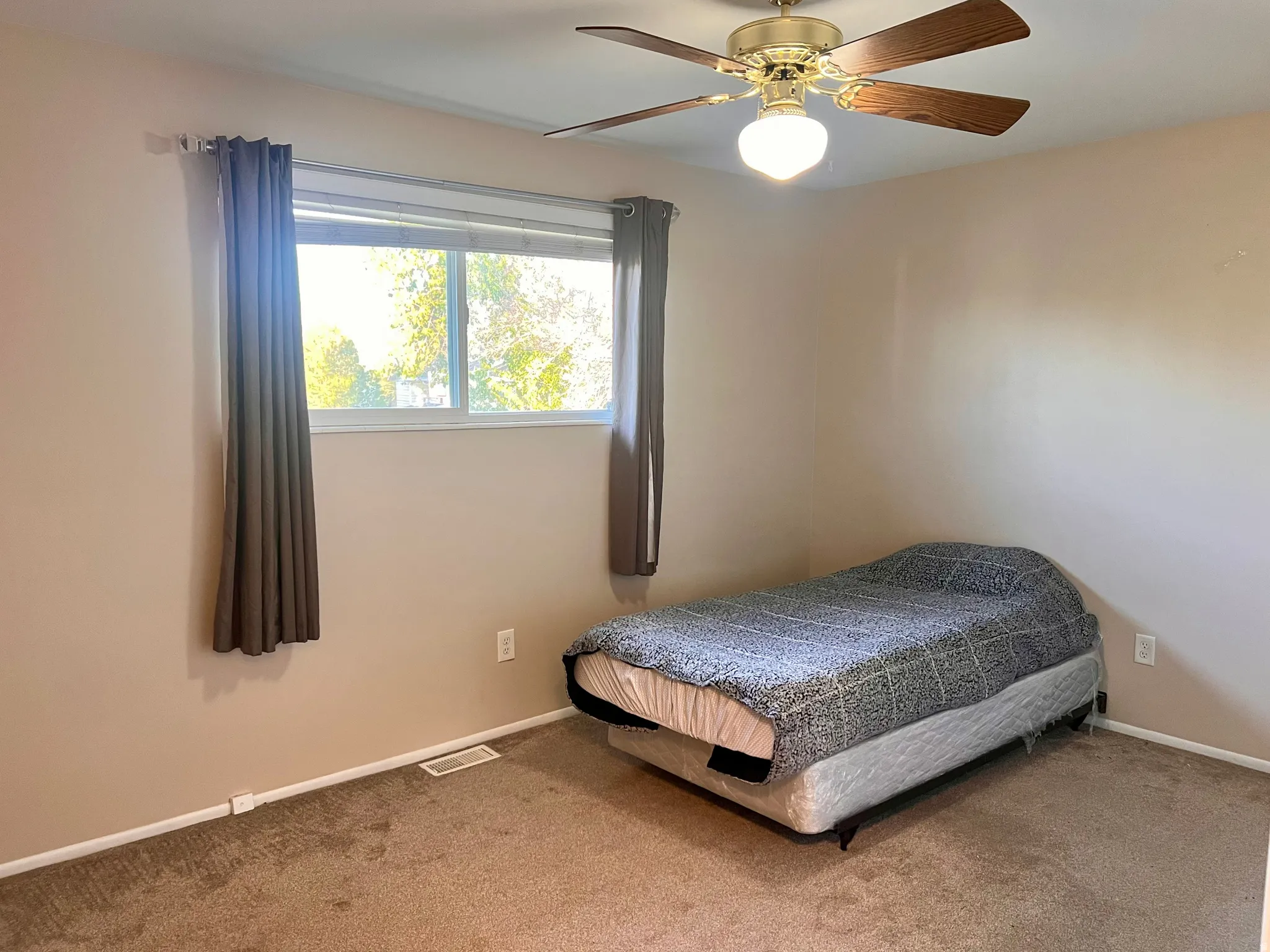 Carpeted bedroom featuring ceiling fan and baseboards
