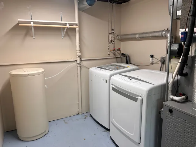 Laundry area with concrete floors, heating unit, and separate washer and dryer