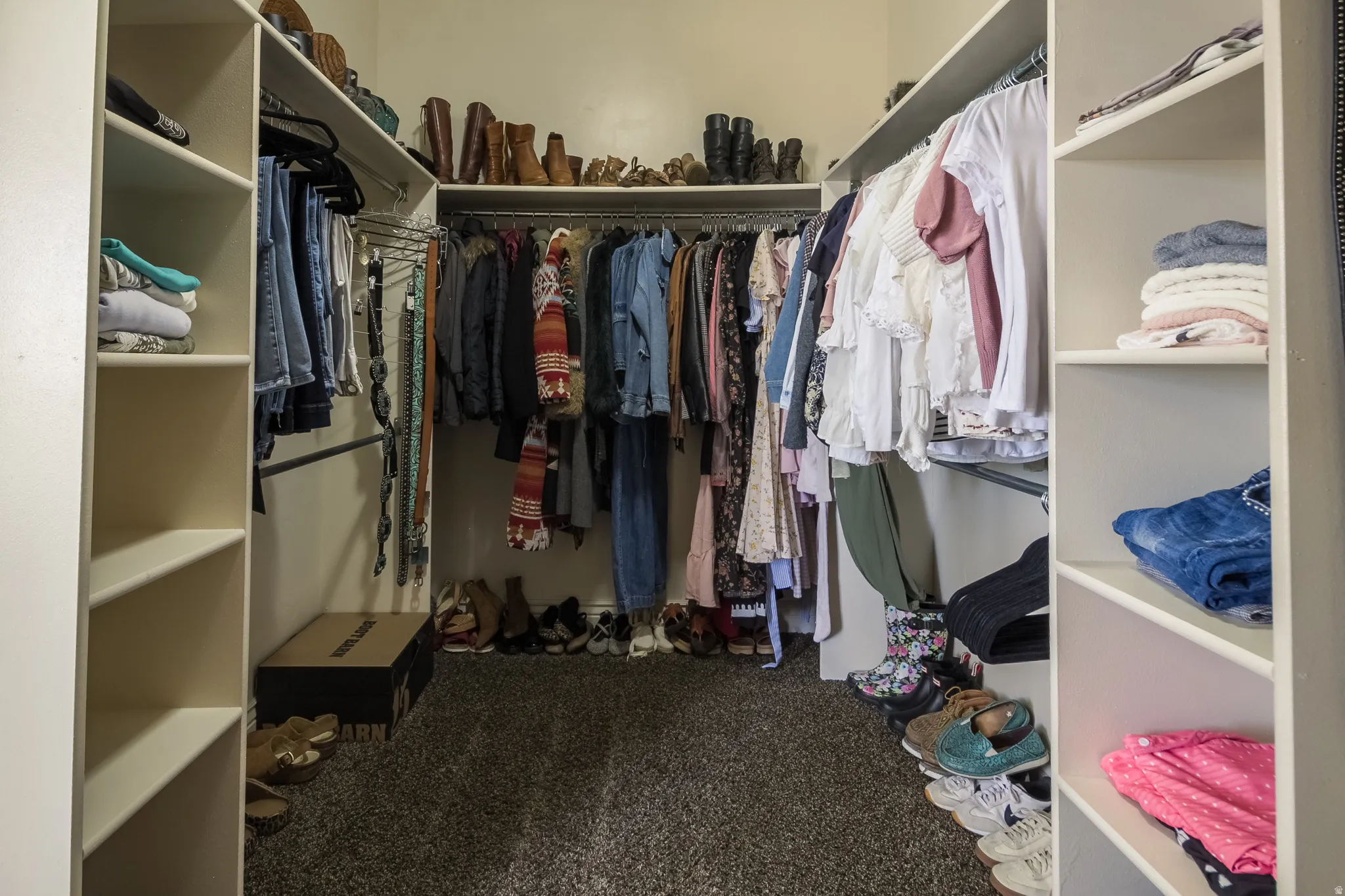 Walk in closet featuring dark carpet