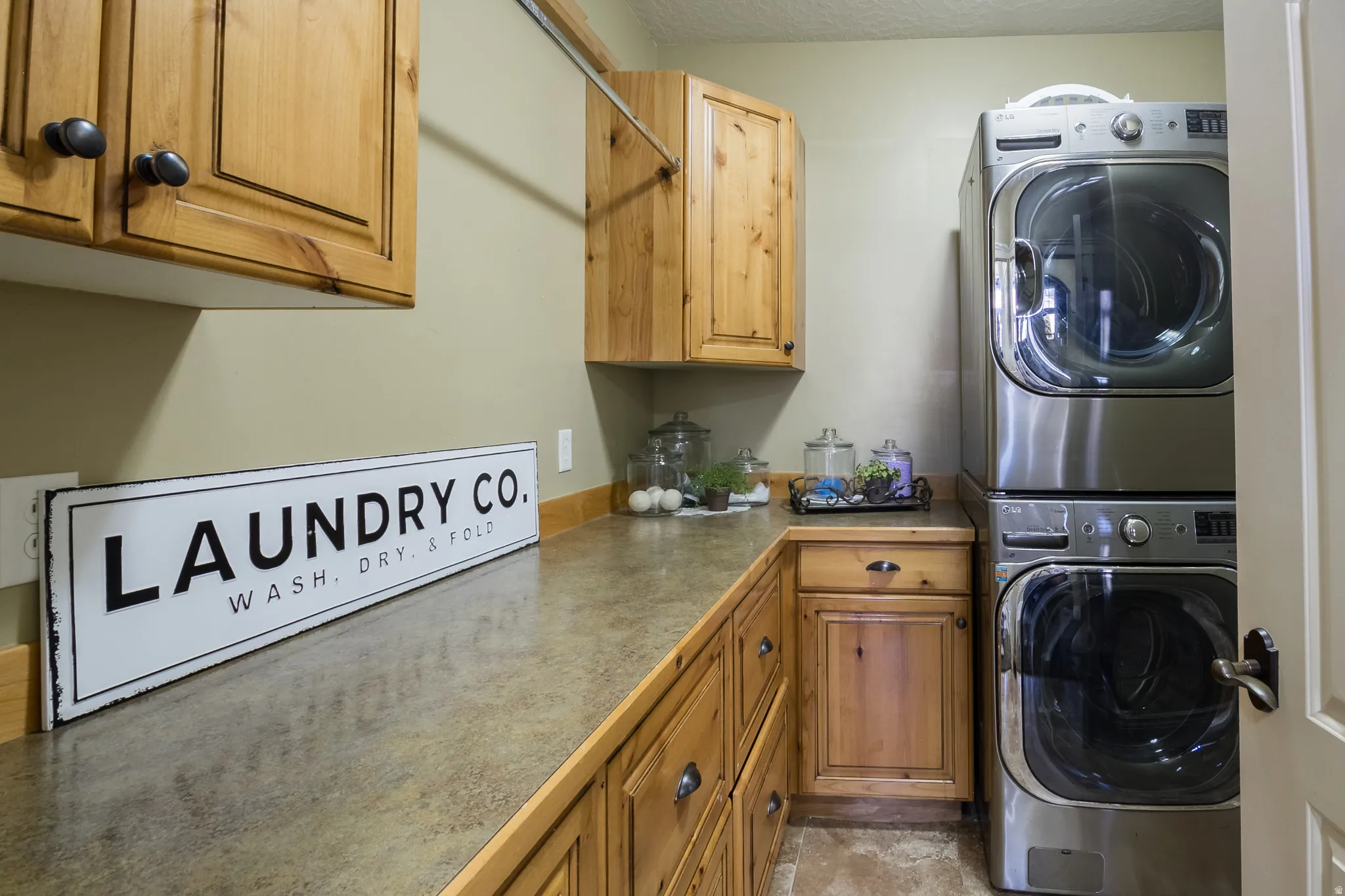Laundry area featuring cabinet space and stacked washer and dryer