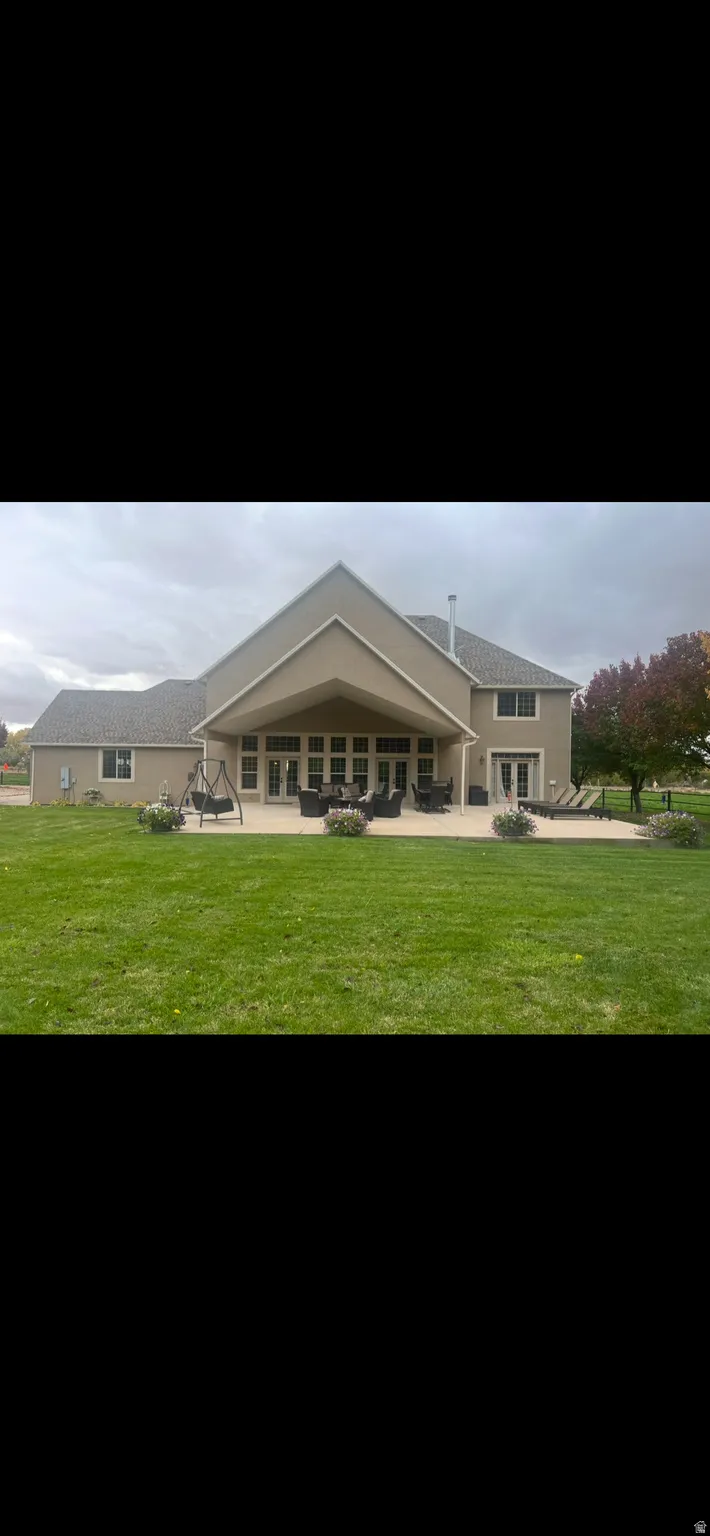 Back of house with a yard and a patio area