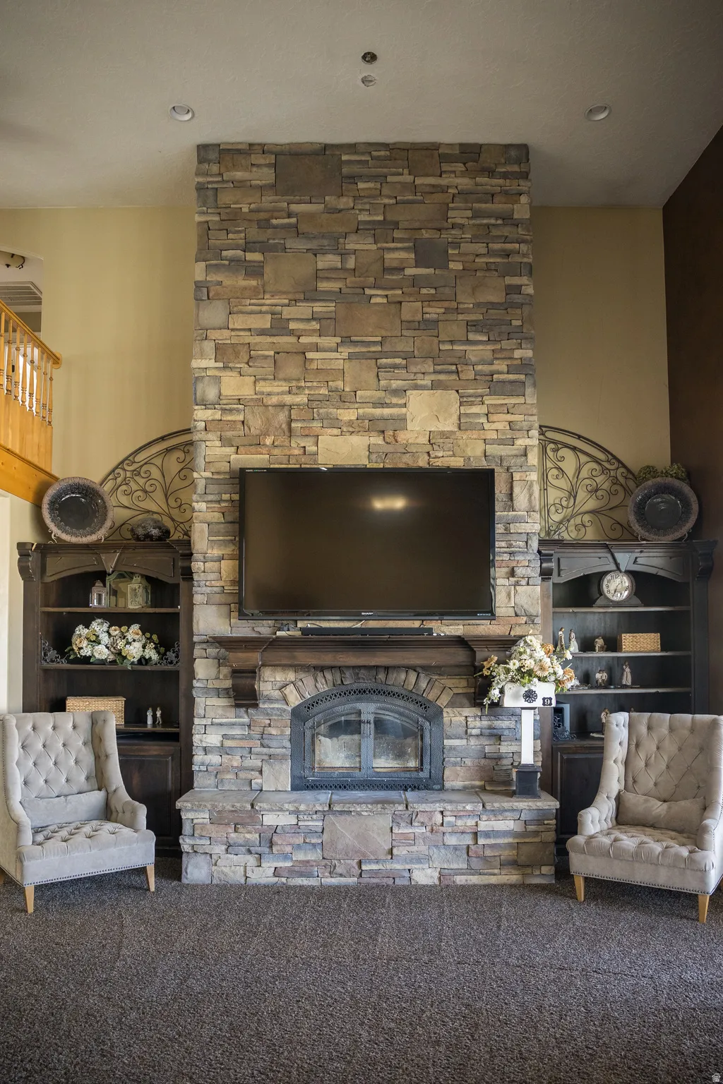 Carpeted living area with a stone fireplace