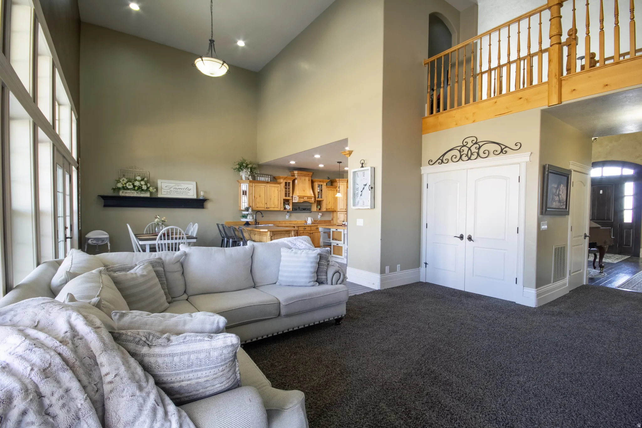 Living area with recessed lighting, arched walkways, carpet flooring, and a high ceiling