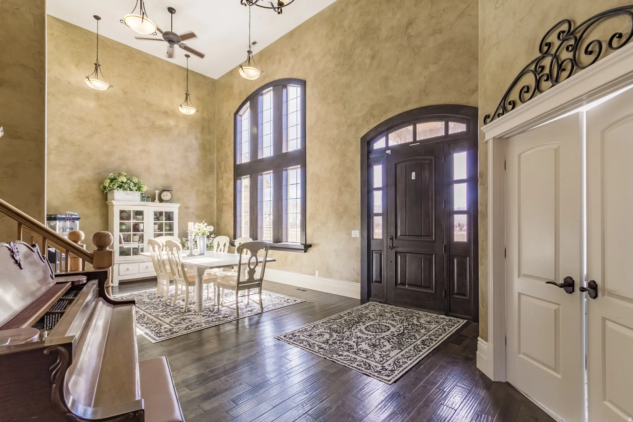 Foyer with a high ceiling, a ceiling fan, and dark wood finished floors