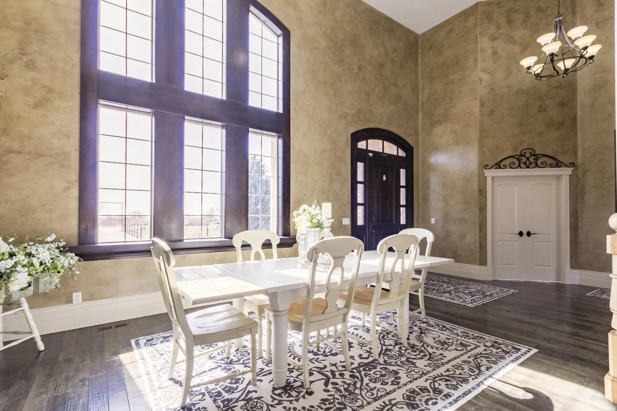 Dining room featuring a high ceiling, dark wood finished floors, and suspended lighting