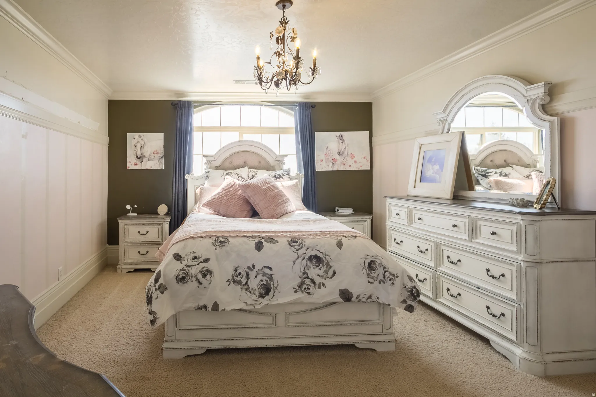 Bedroom featuring light carpet, hanging lights, multiple windows, and ornamental molding