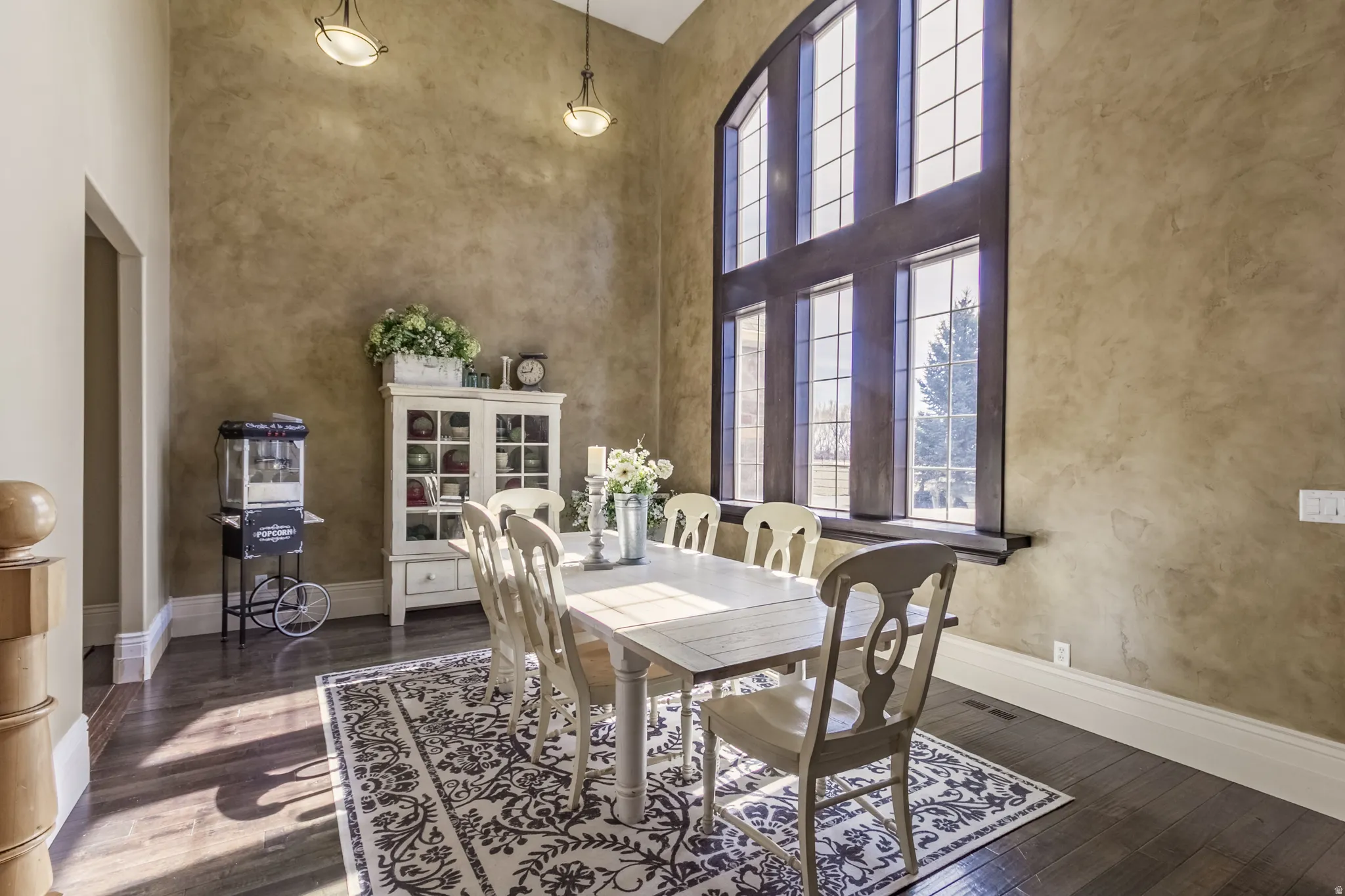Dining area with a high ceiling and dark wood-type flooring