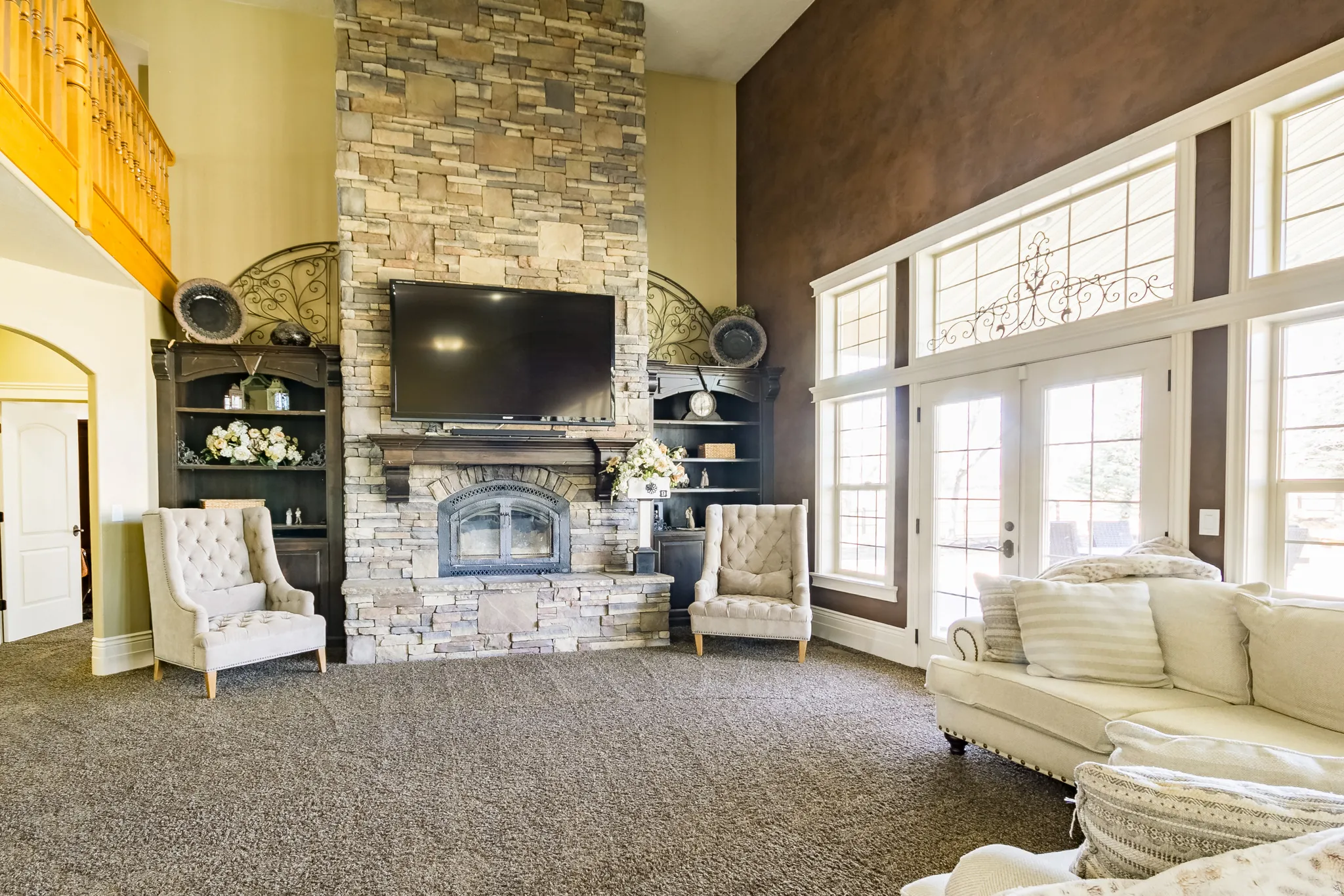 Living room with a high ceiling, a fireplace, carpet, and french doors