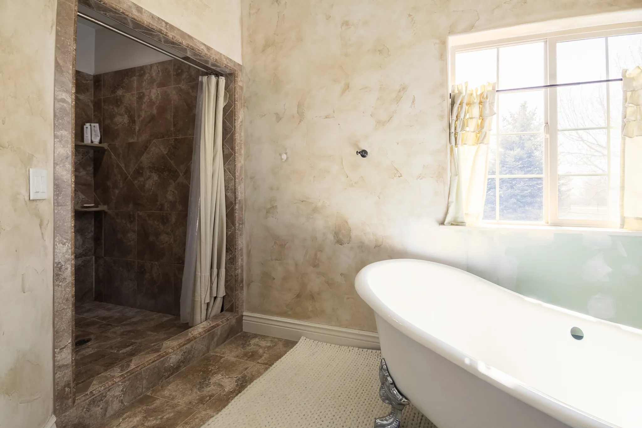 Bathroom with a stall shower and a freestanding bath
