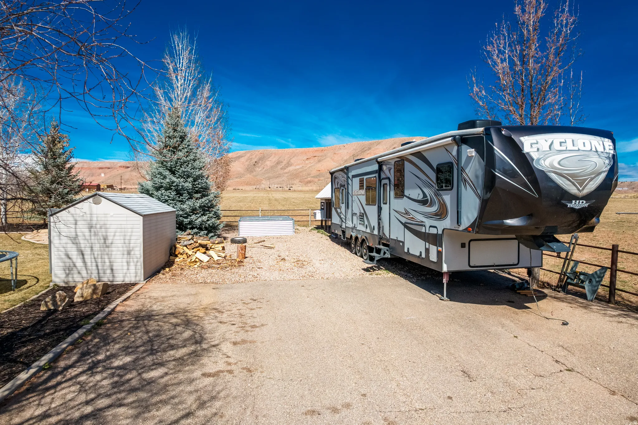 View of parking with a storage shed, a trampoline, and a mountain view