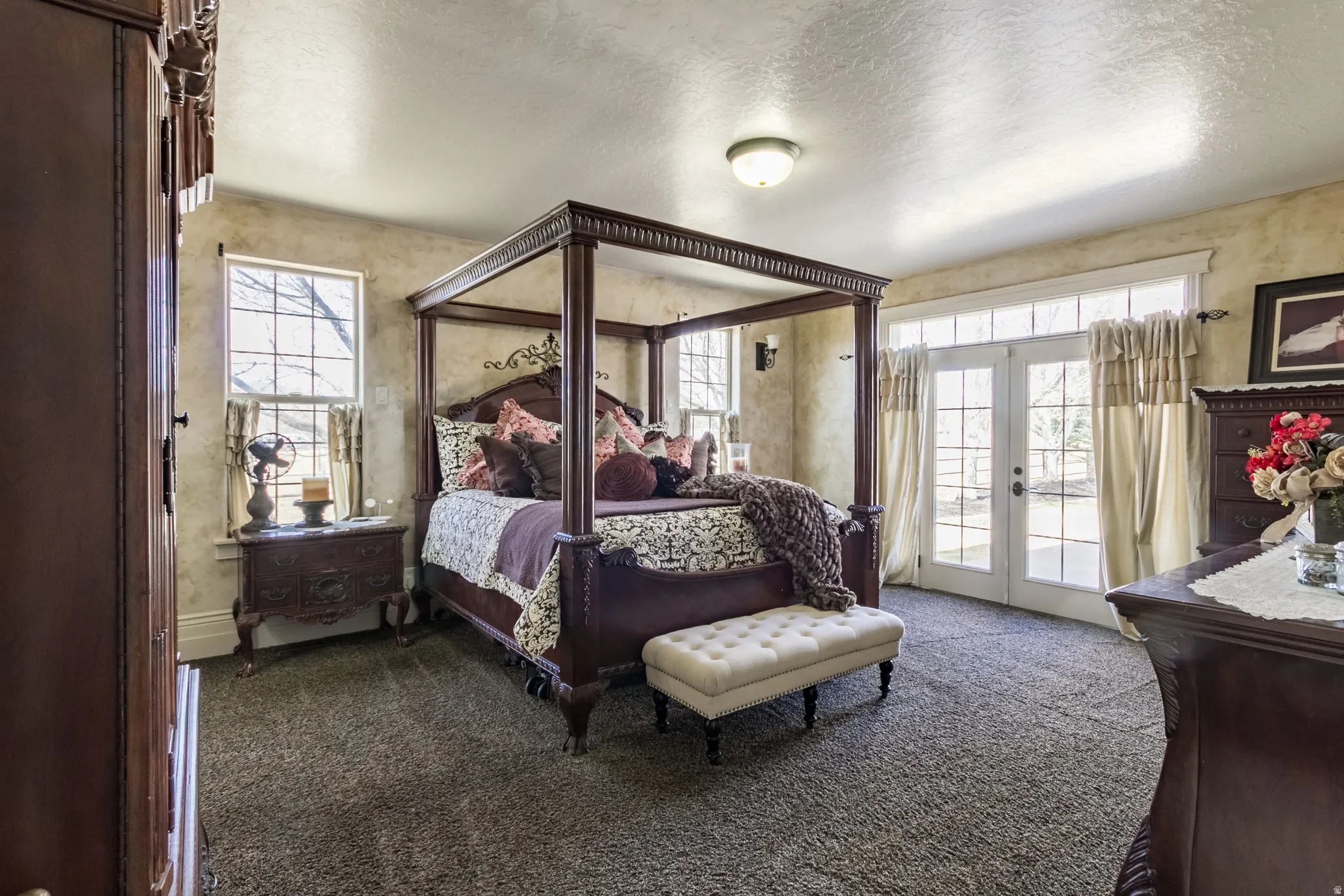 Bedroom with french doors, a textured ceiling, dark carpet, and access to outside