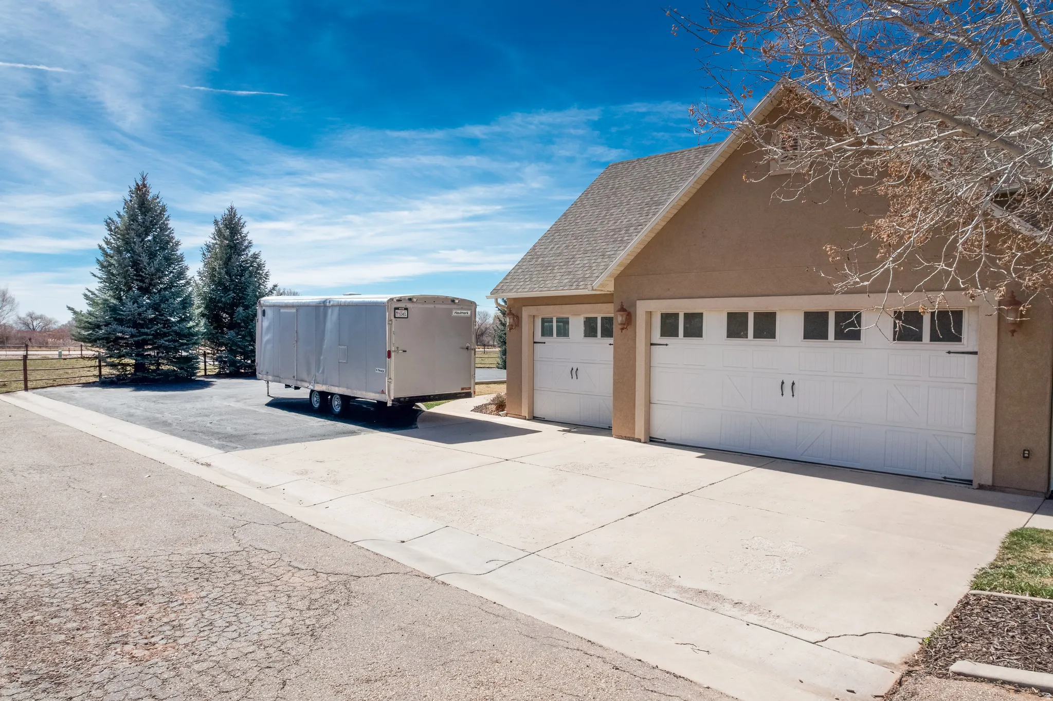 View of side of home featuring stucco siding, a shingled roof, and a garage