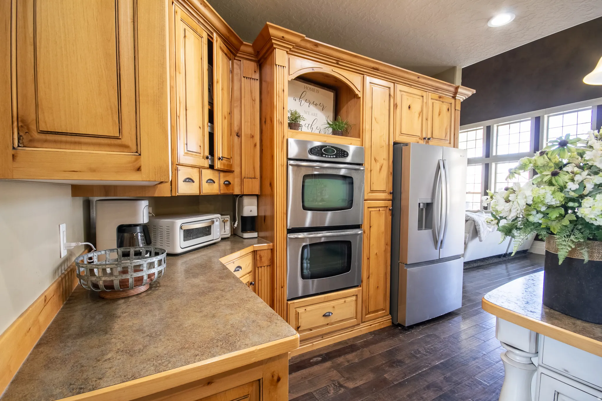 Kitchen featuring stainless steel appliances, dark wood-type flooring, open shelves, and a textured ceiling