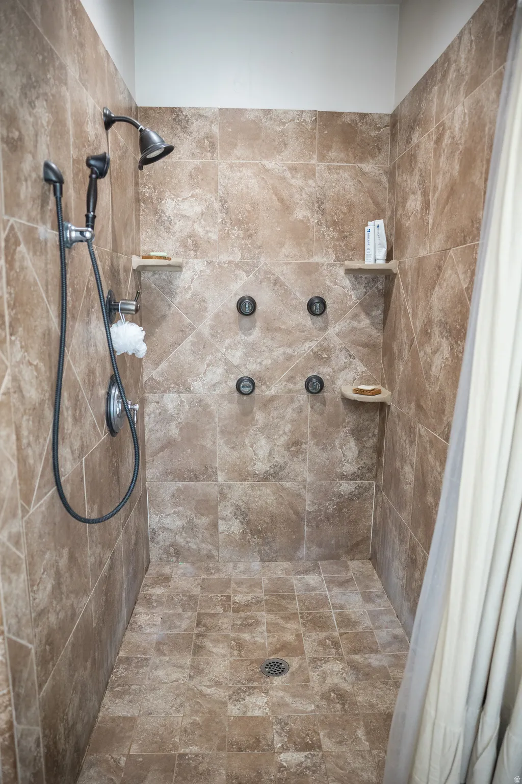Full bath featuring tiled shower