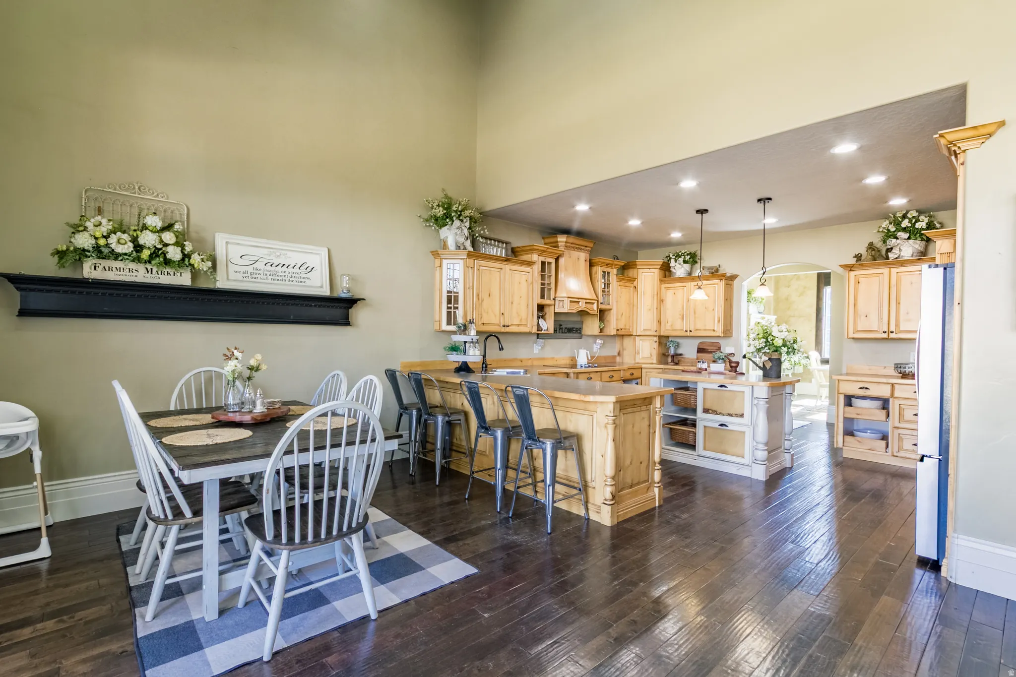 Dining room with recessed lighting, arched walkways, dark wood-type flooring, and a high ceiling