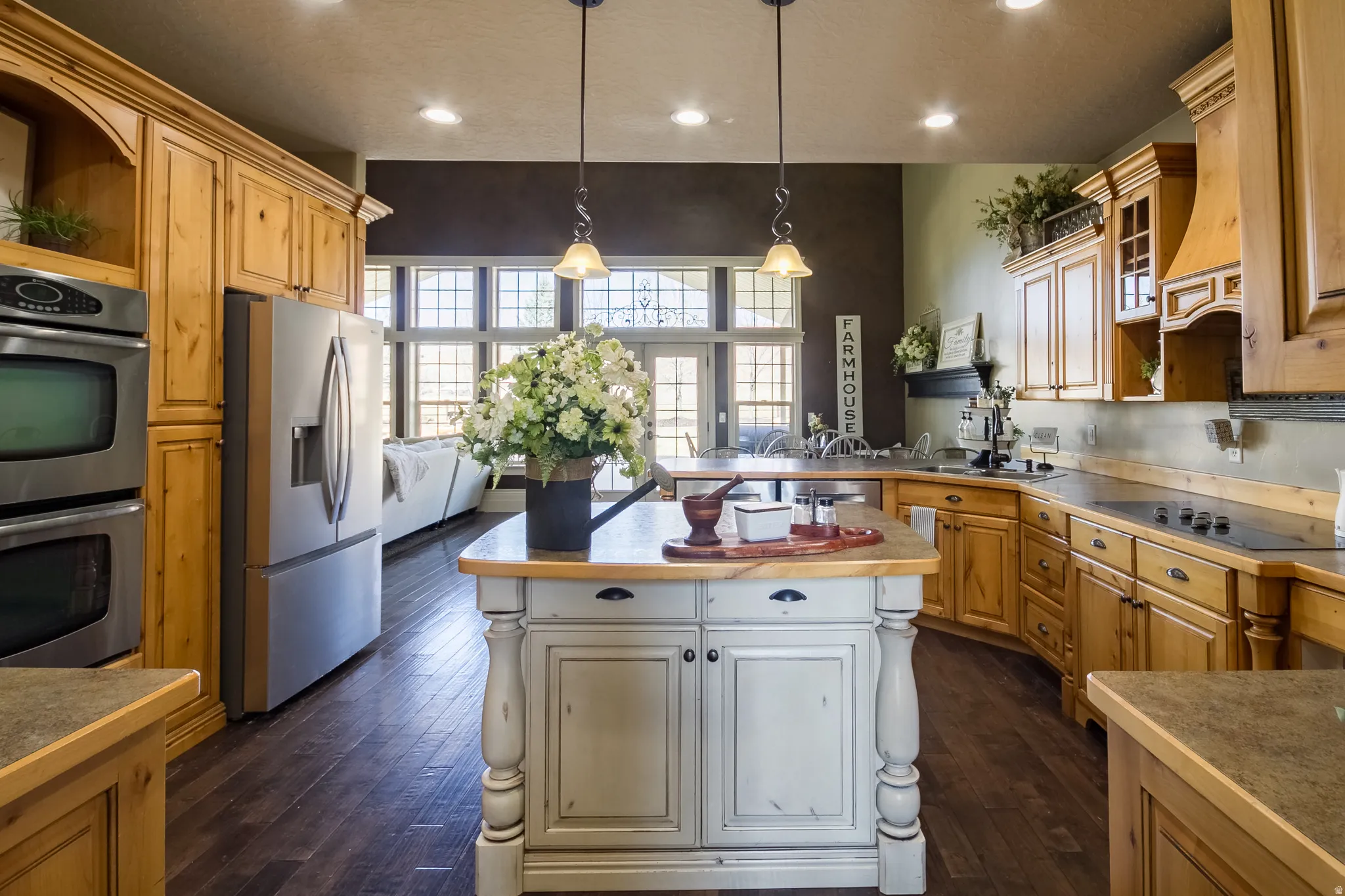 Kitchen featuring open shelves, stainless steel appliances, pendant lighting, dark wood-style floors, and a kitchen island