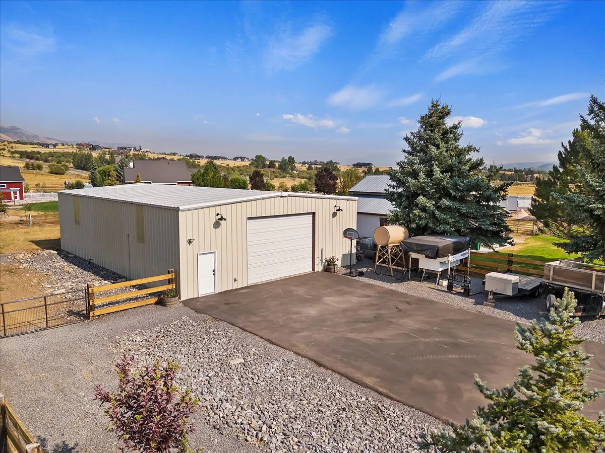 Detached garage featuring driveway and a gate