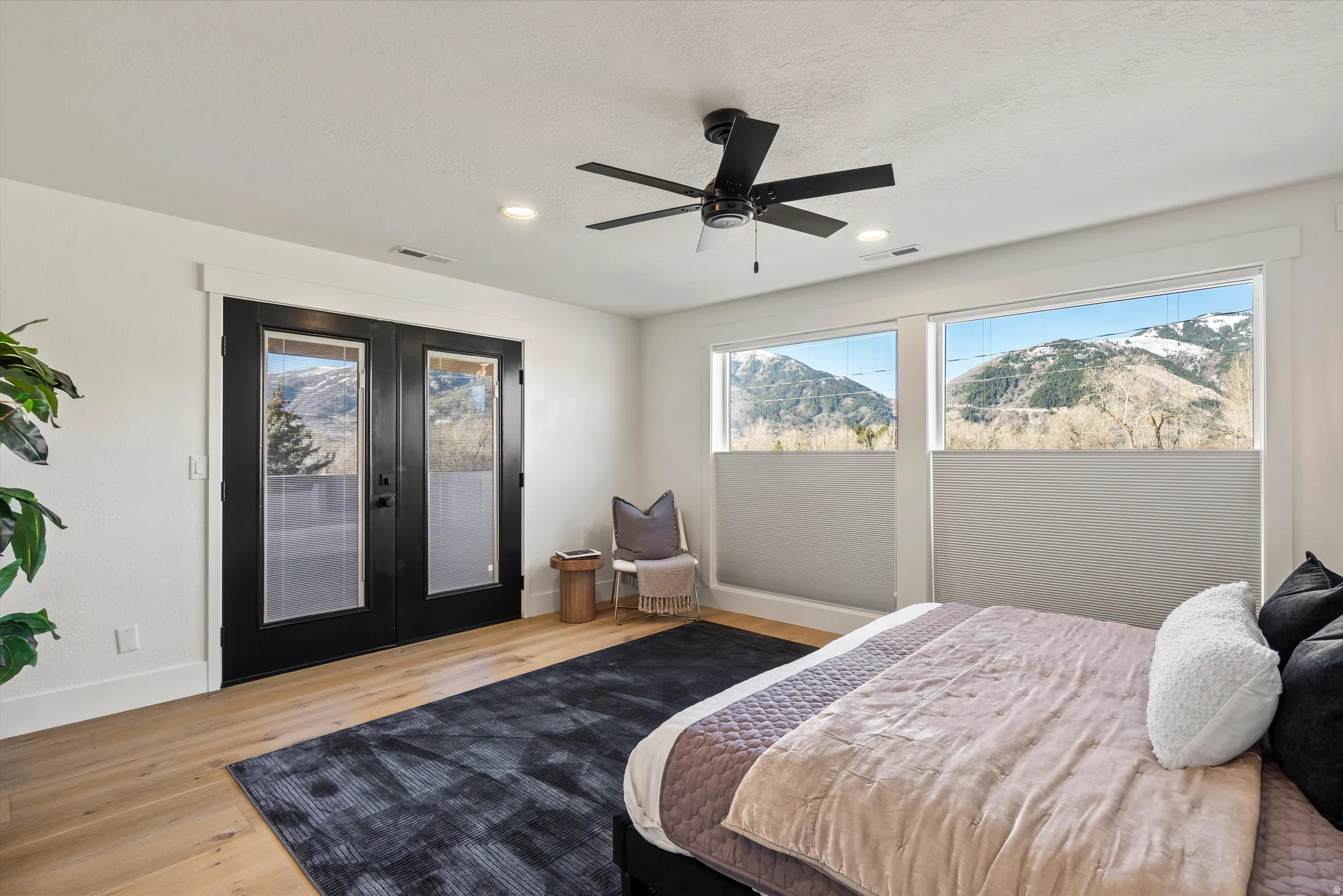 Bedroom featuring french doors, a mountain view, access to exterior, light wood-style flooring, and ceiling fan