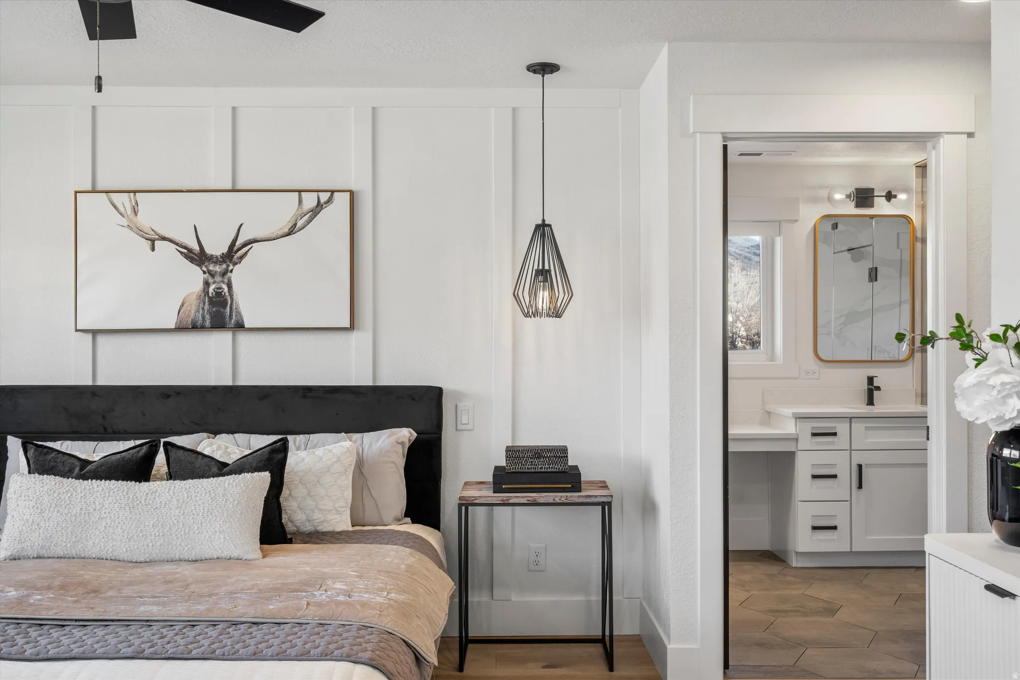 Bedroom with ceiling fan, ensuite bath, and wood finished floors
