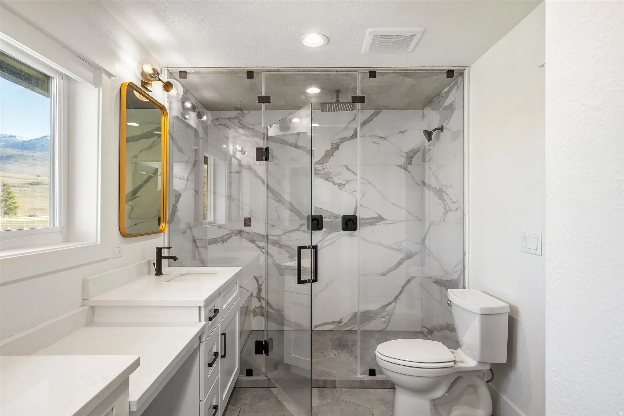 Full bath with vanity and a marble finish shower