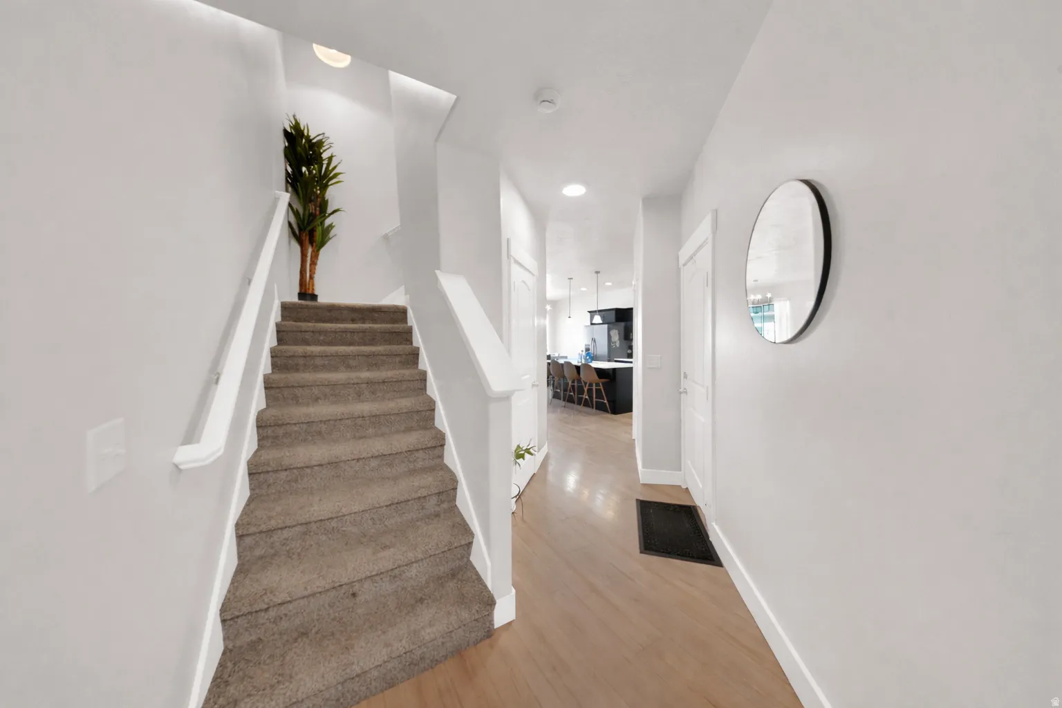 Stairs with wood finished floors and recessed lighting