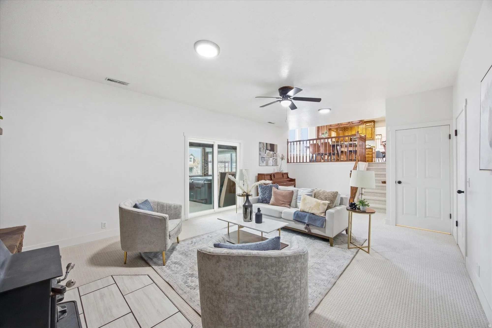 Living area featuring light carpet and ceiling fan