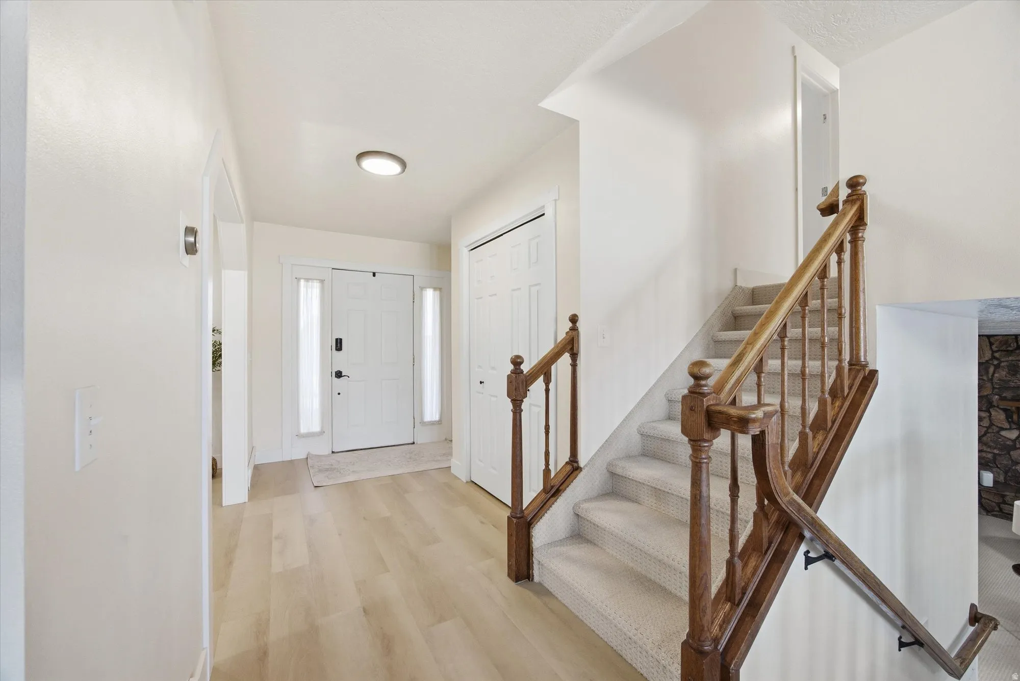 Foyer featuring light LVP flooring and staircase