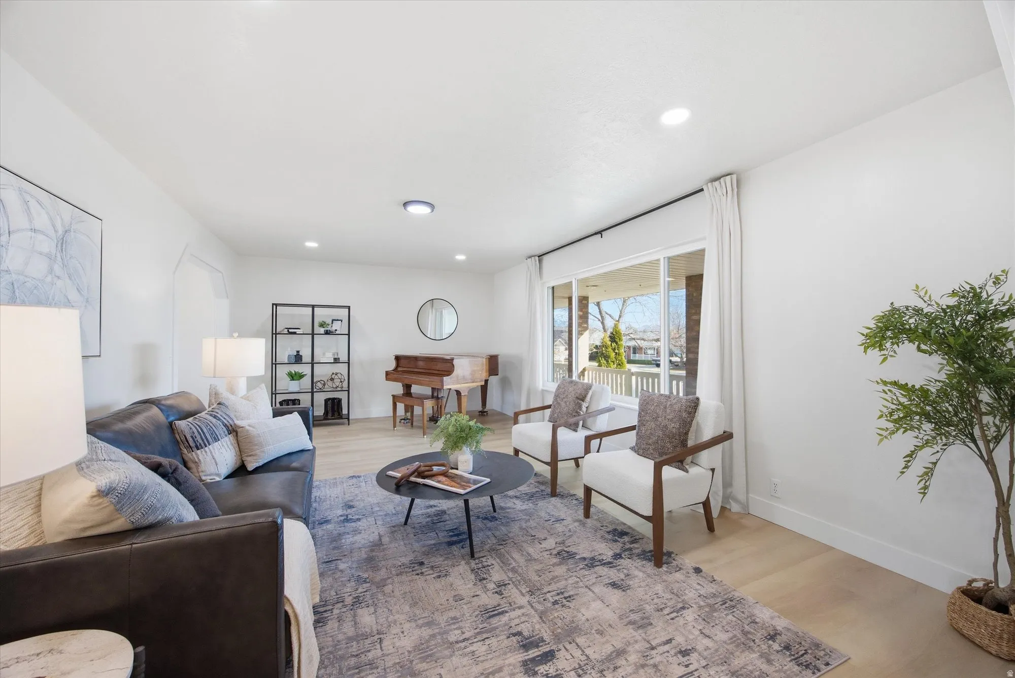 Living area with light LVP flooring and recessed lighting