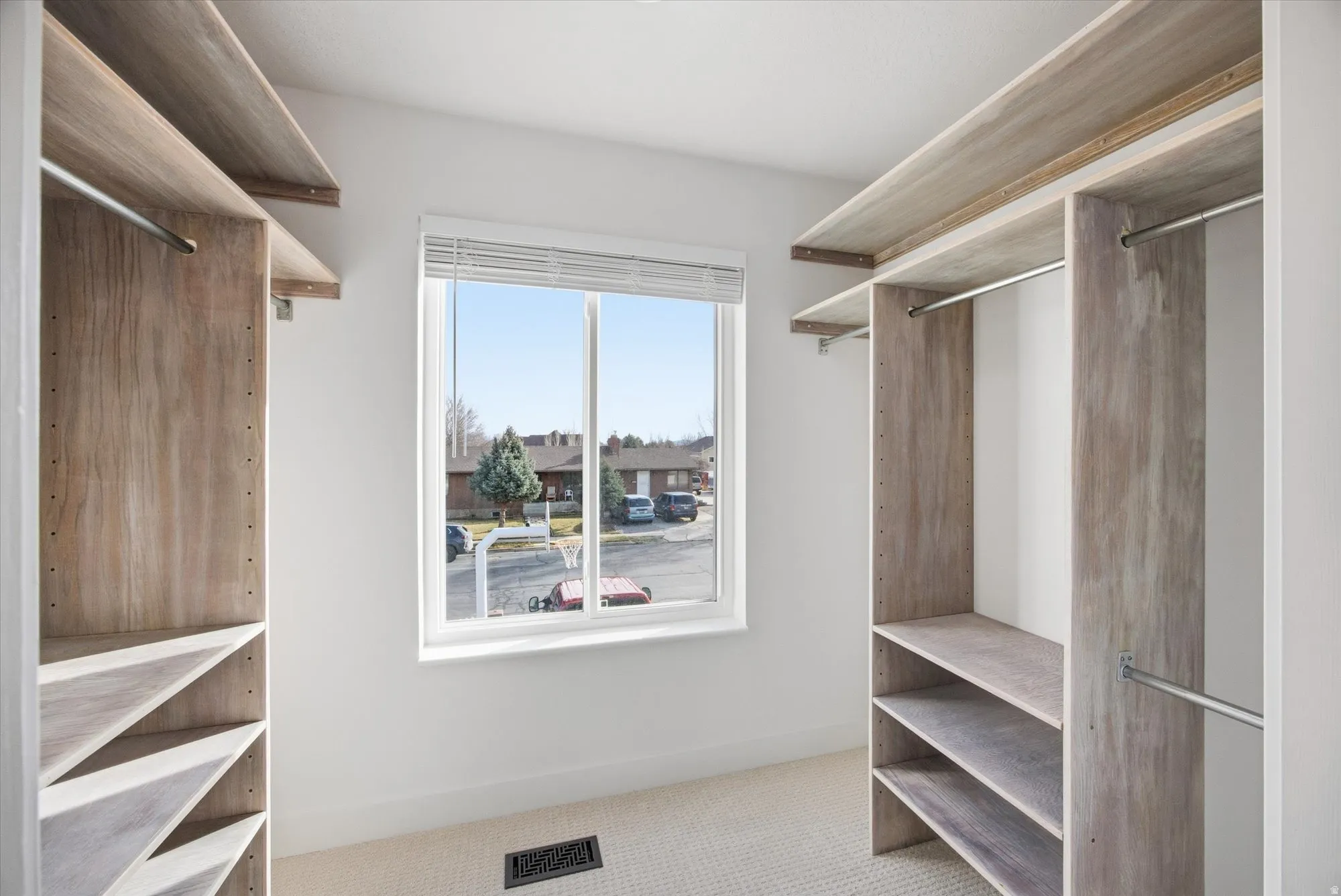 Walk in closet featuring light colored carpet